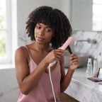 Mini lisseur de voyage GlowStyler noir, utilisé par une femme